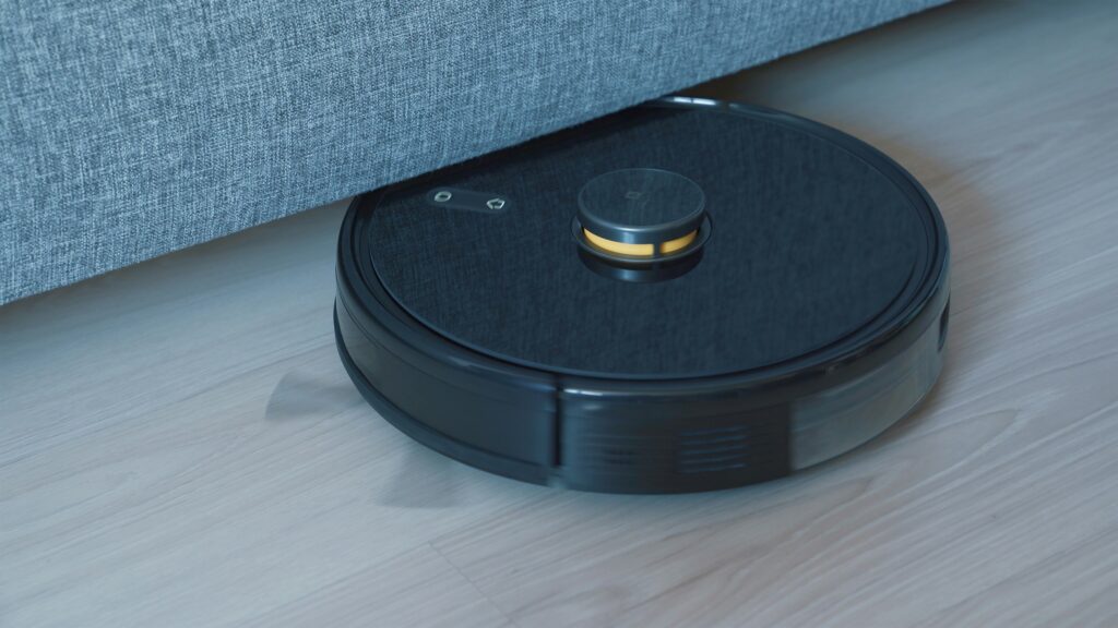 Robot aspirador con ruedas de goma sobre suelo de madera